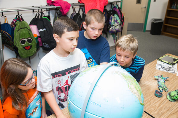 kids looking at a globe